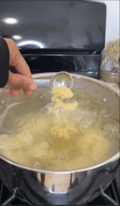 Mashing boiled cassava to create the dough for these Cheesy Yuca Bites.