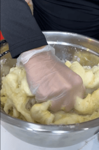 Stuffing white cheese inside the Cheesy Yuca Bites before frying.