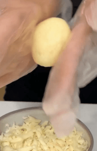 Frying Cheesy Yuca Bites in a pan until they reach a golden brown crust.