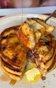 Banana Bread Chocolate Chip Pancakes stacked with maple syrup